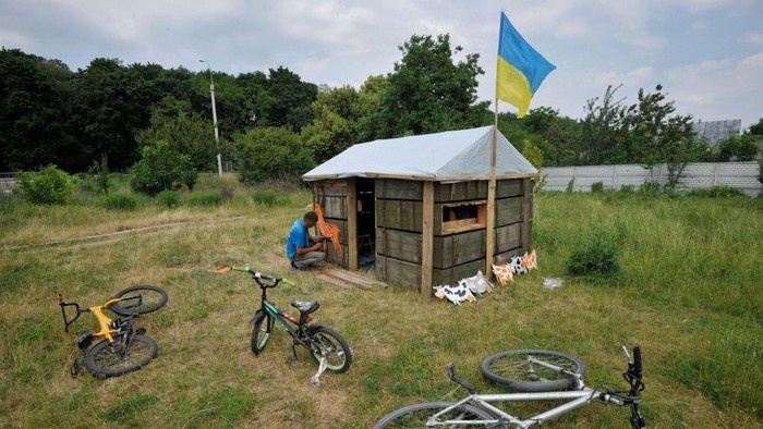 Saat Peti Bekas Amunisi Disulap Jadi Tempat Main Anak-anak Ukraina, Begini Jadinya Children play in a toy cabin made of used ammunition crates in the village of Novoselivka, outside Chernigiv, on June 21, 2022, amid the Russian invasion of Ukraine. (Photo by Sergei CHUZAVKOV / AFP) (Photo by SERGEI CHUZAVKOV/AFP via Getty Images)