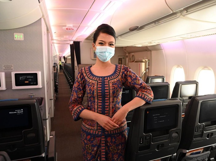 Seragam Pramugari Singapore Airlines A Singapore Airlines stewardess poses along the aisle during a media tour onboard a Singapore Airlines Airbus A380 at Changi International Airport in Singapore on October 24, 2020. (Photo by ROSLAN RAHMAN / AFP) (Photo by ROSLAN RAHMAN/AFP via Getty Images)