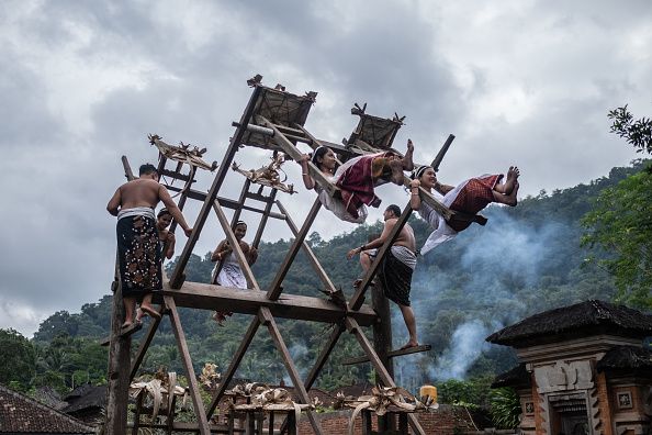 BALI, INDONESIA - JUNE 23: Women from Indigenous community of Tenganan Pegringsingan ride ancient spinning wheels called Ayunan Jantra after the Pandanus war ritual called Mekare-Kare on June 23, 2022 in Tenganan Pegringsingan Village, Bali, Indonesia. The ancient 