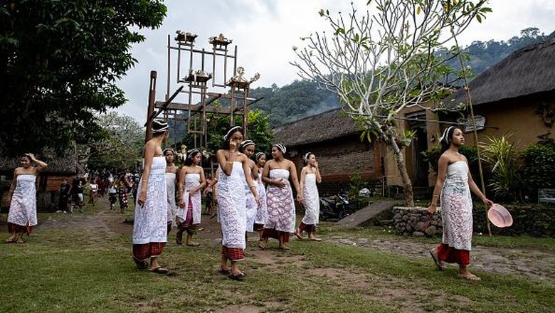 BALI, INDONESIA - JUNE 23: Women from Indigenous community of Tenganan Pegringsingan ride ancient spinning wheels called Ayunan Jantra after the Pandanus war ritual called Mekare-Kare on June 23, 2022 in Tenganan Pegringsingan Village, Bali, Indonesia. The ancient Bali Aga Tenganan Pegringsingan village is different from the other villages in Bali, especially in their belief in the God of Indra and Balinese culture are intertwined in the communitys daily life. The village also has its own territory and preserves its traditions in ways contrasting those found in other villages in Bali. Tengananese people on the island of Bali celebrate a month long ceremony called Usabha Sambah to demonstrate respect to the God Indra, the Hindu god of war. One of the rituals during the ceremony is a Pandanus War or Mekare Kare, where two Tengananese men duel each other to shed the blood for the offerings. The tradition originated from a belief that they have to make blood sacrifices to Indra. When the men and boys shed their blood during the battle, this is the ultimate sacrifice and devotion to Indra, and also shows dedication to their community. (Photo by Agung Parameswara/Getty Images)