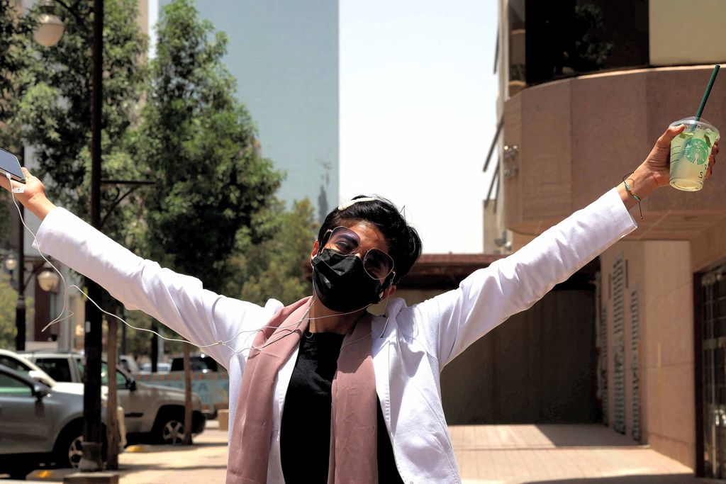 Safi, a 26-year-old Saudi physician, poses for a photo with her short hair near the Kingdom Centre skyscraper in the centre of Saudi Arabia's capital Riyadh on June 19, 2022. - When Saudi doctor Safi took a new job at a hospital in the capital, she decided to offset her standard white lab coat with a look she once would have considered dramatic. Walking into a Riyadh salon, she ordered the hairdresser to chop her long, wavy locks all the way up to her neck, a style increasingly in vogue among working women in the conservative kingdom. The haircut - known locally by the English word 