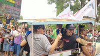 Warga terlihat berdesakan untuk dapat bersalaman dengan para pembalap. Mereka juga mengabadikan momen konvoi tersebut menggunakan handphone. Foto: Faruk Nickyrawi