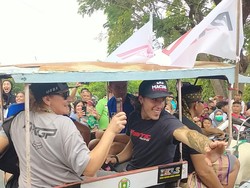 Warga terlihat berdesakan untuk dapat bersalaman dengan para pembalap. Mereka juga mengabadikan momen konvoi tersebut menggunakan handphone. Foto: Faruk Nickyrawi