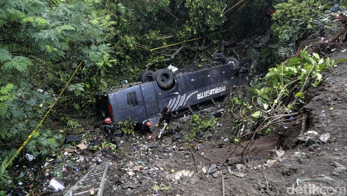 Begini Kondisi Bus yang Masuk Jurang di Tasikmalaya Polisi menuruni tebing saat melakukan olah tempat kejadian perkara kecelakaan bus pariwisata yang masuk jurang di Kampung Cirendeu, Desa Manggungsari, Kecamatan Rajapolah, Kabupaten Tasikmalaya, Jawa Barat, Sabtu (25/6/2022). Empat orang tewas dalam kecelakaan tunggal bus pariwisata yang berpenumpang rombongan guru dan staf SDN Sayang, Jatinangor, Kabupaten Sumedang tersebut. ANTARA FOTO/Humas Polres Tasikmalaya Kota/Handout/ADB/wsj.