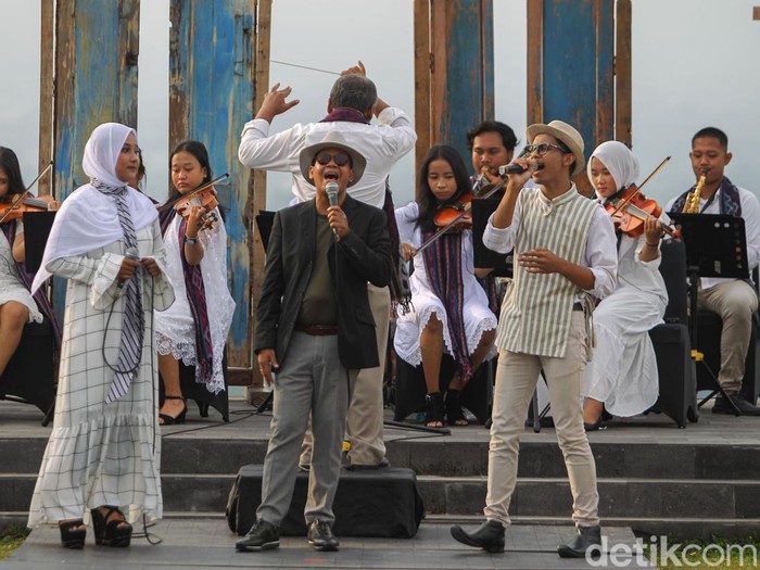 Desainer Phillip Iswardono (memakai jas hitam) menyanyi sebelum fashion show tunggalnya dimulai di Candhari Heaven, Prambanan, Sleman, DIY, Sabtu (25/6/2022).