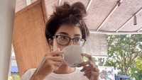 Terlihat seperti baru bangun tidur, Widi Vierratale pun langsung menyeruput secangkir minuman. Foto: Instagram @_widikidiw_