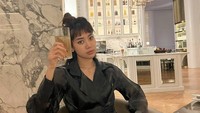 Inilah gaya keren Widi Vierratale yang sedang berpose memegang minuman di gelas bening sambil duduk-duduk cantik. Foto: Instagram @_widikidiw_