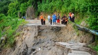 Jalan akses utama pedesaan tersebut amblas akibat tergerus aliran air dari bukit.