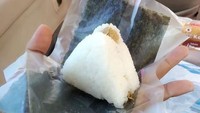 Baru pertama kali mencicipi onigiri minimarket, netizen ini tak tahu cara membuka kemasannya. Asal membuka saja, onigirinya berujung polos tanpa rumput laut. Foto: Twitter/txtdrkuliner