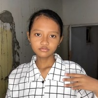 Awalnya gadis dalam video tampak pucat tanpa mengenakan makeup sama sekali dan hanya mengenakan kemeja kotak-kotak berwarna putih. Rambutnya pun terlihat hanya dikat ke belakang. Foto: TikTok/@panggilakunano
