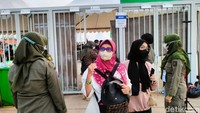 Mereka terlebih dahulu diperiksa petugas keamanan sebelum memasuki pintu masuk JIS.
