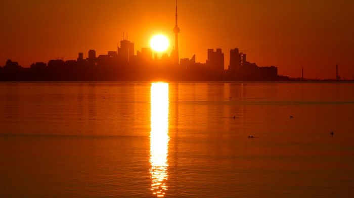 TORONTO, ONT - JUNE 24: The sun rises behind the downtown skyline and the CN Tower on June 24, 2022, in Toronto, Ontario. (Photo by Gary Hershorn/Getty Images)