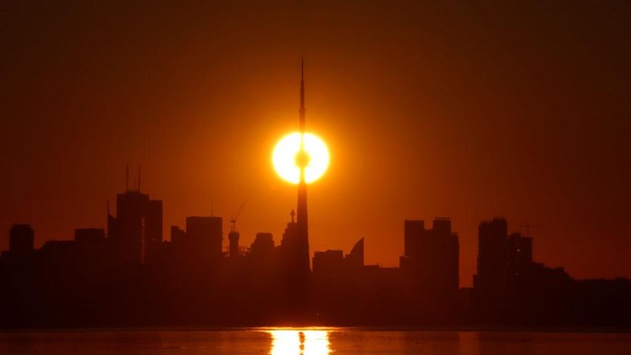 1404974113 TORONTO, ONT - JUNE 24: The sun rises behind the downtown skyline and the CN Tower on June 24, 2022, in Toronto, Ontario. (Photo by Gary Hershorn/Getty Images)