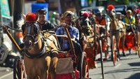 Arak-arakan bendi dan bugih melintasi kawasan Pasar Padangpanjang, Sumatera Barat, Minggu (26/6/2022).
