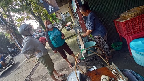 Nyoman Jumartini saat menyiapkan Es Waneng untuk pembelinya, Minggu (26/6/2022).