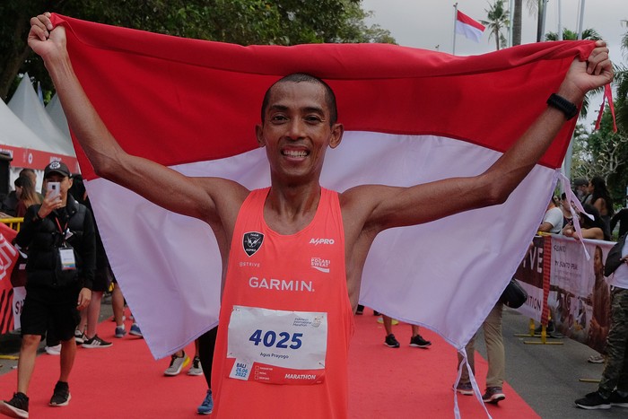 Pelari Indonesia Agus Prayogo berselebrasi saat menyelesaikan perlombaan dengan finis di urutan pertama dengan catatan waktu 2 jam 36 menit 14 detik pada kategori Full Marathon 42 kilometer putra dalam Indonesia International Marathon (IIM) di Sanur, Denpasar, Bali, Minggu (26/6/2022). Kegiatan Marathon yang dibagi empat kategori yakni Full Marathon 42 kilometer, Half Marathon 21 kilometer, 10 kilometer dan 5 kilometer tersebut diikuti 3.500 pelari dari 20 negara dengan rute melintasi kawasan objek wisata Sanur dan Kuta untuk pemulihan pariwisata dan ekonomi Bali akibat terdampak pandemi COVID-19. ANTARA FOTO/Nyoman Hendra Wibowo/foc.