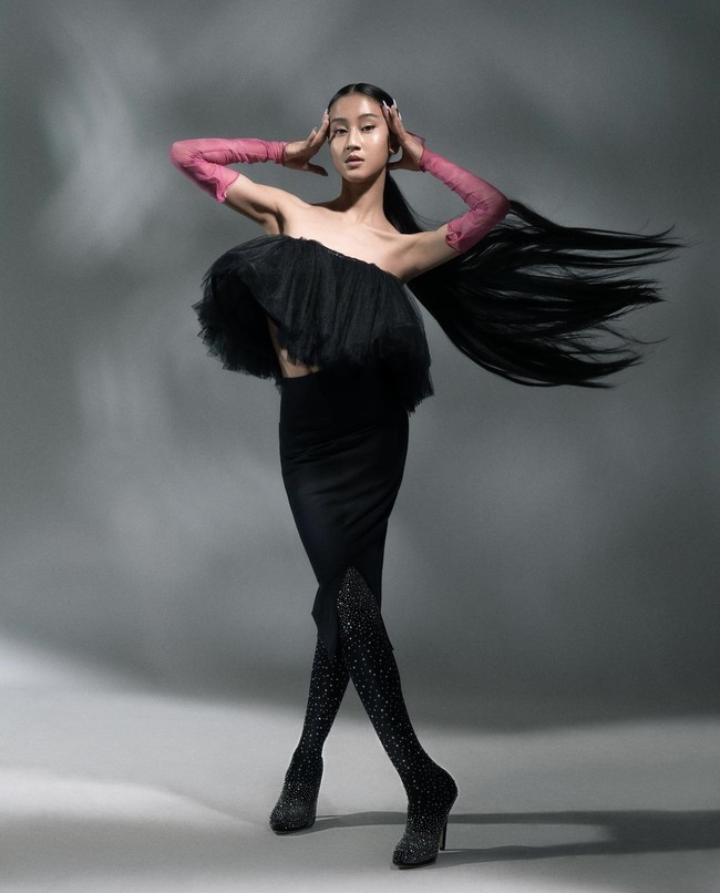 Dia berani tampil beda saat memakai dress asimetris yang dipadukan dengan long heeled boots dan arm sleeves berwarna pink. Dengan rambut extension dan ekspresi smize, Keisya Lavronka dinilai cocok ikut kontes Indonesia’s Next Top Model. Foto: dok. Instagram @keisyalevronka