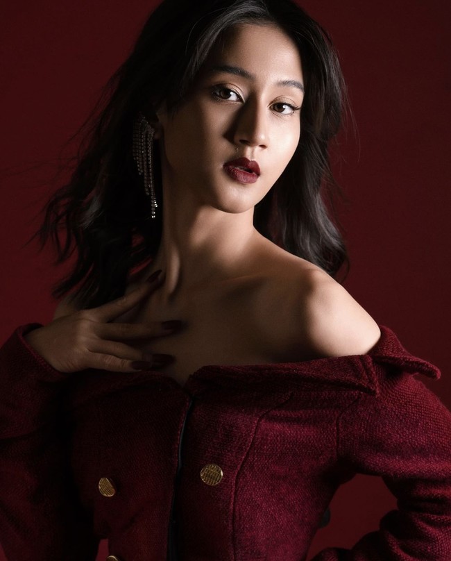 Dalam salah satu pemotretan, Keisya Lavronka tampil berani dengan make up bold. Dia memakai lipstik merah tua yang senada dengan dress dan background fotonya. Foto: dok. Instagram @keisyalevronka