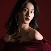 Dalam salah satu pemotretan, Keisya Lavronka tampil berani dengan make up bold. Dia memakai lipstik merah tua yang senada dengan dress dan background fotonya. Foto: dok. Instagram @keisyalevronka