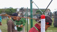 Peserta lomba jemparingan mataraman mengambil anak panah yang menancap tepat sasaran berwarna merah dan putih saat mengikuti sayembara jemparingan mataraman dalam rangka memperingati Hadeging Kadipaten Pakualaman ke-210 di lapangan Kopertis, Jogja. Foto: Pius Erlangga/detikJateng