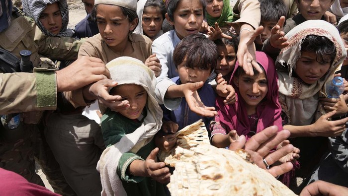 Afghan children line up for bread at a camp after an earthquake in Gayan district in Paktika province, Afghanistan, Sunday, June 26, 2022. A powerful earthquake struck a rugged, mountainous region of eastern Afghanistan early Wednesday, flattening stone and mud-brick homes in the country's deadliest quake in two decades, the state-run news agency reported. (AP Photo/Ebrahim Nooroozi)