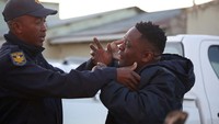Seorang anggota keluarga korban menangis saat meminta penjelasan dari aparat terkait kematian puluhan remaja di sebuah bar di Afrika Selatan.
