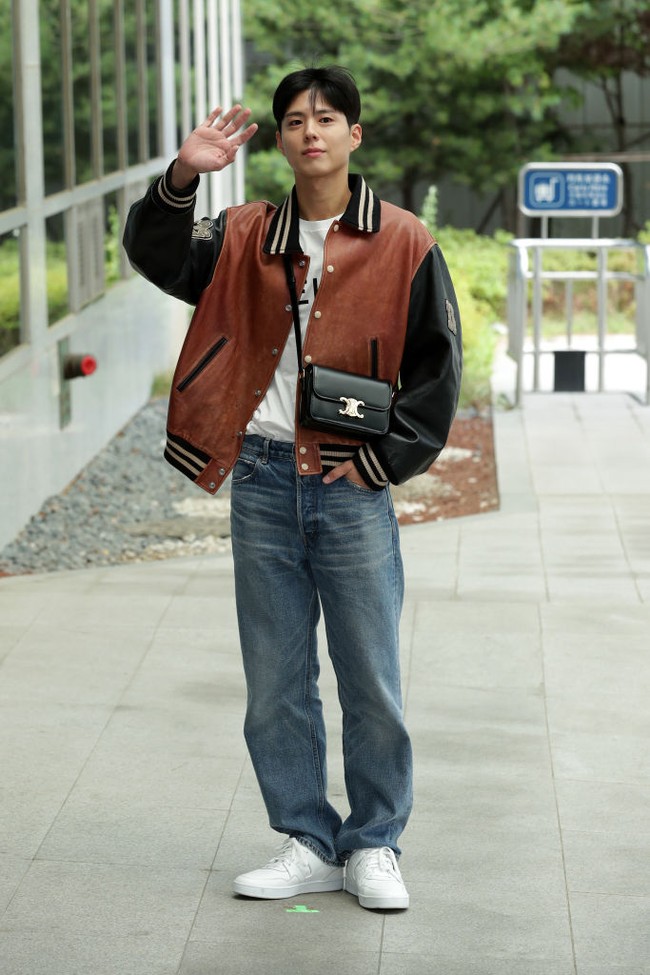 Penampilan Park Bo Gum saat tiba di Bandara Internasional Gimpo, sebelum terbang ke Paris pada 24 Juni 2022. Sang aktor memakai t-shirt putih Celine dipadu jaket varsity, jeans dan sneakers. Foto: Getty Images