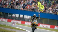 MotoGP Belanda 2022 jadi momen istimewa buat Marco Bezzecchi. Ia merayakannya dengan bendera yang erat nuansanya dengan Valentino Rossi. Foto: Getty Images/Steve Wobser