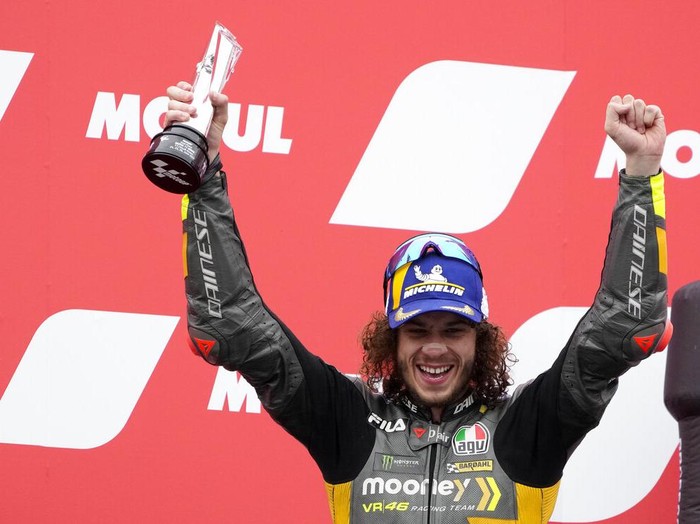 Second placed Italian rider Marco Bezzecchi of the Mooney VR46 Racing Team celebrates with trophy on the podium after the MotoGP race at the Dutch Grand Prix in Assen, northern Netherlands, Sunday, June 26, 2022. (AP Photo/Peter Dejong)