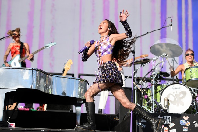 Untuk aksi panggungnya di salah satu festival musik terbesar di dunia itu, Olivia Rodrigo mengandalkan tampilan busana ala rocker 90-an yang selama ini menjadi ciri khas gayanya. (Foto: Redferns/Matthew Baker)