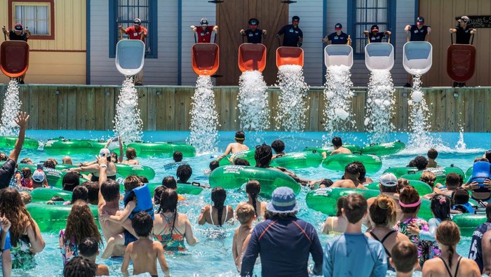Employees dump ice from wheelbarrows into the pool at the Typhoon Texas Waterpark in Katy, Texas, U.S. June 26, 2022.  REUTERS/Go Nakamura     TPX IMAGES OF THE DAY