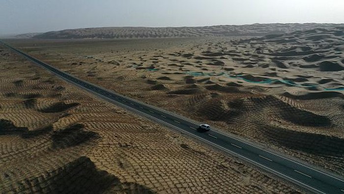 BAZHOU, CHINA - JUNE 26, 2022 - Aerial photo taken on June 26, 2022 shows the beauty of a desert highway in Bazhou, Xinjiang Province, China. Construction of the Desert Highway from Yuli County to Qiemo County in Xinjiang began in October 2017, with a total length of 334 kilometers, of which 307 kilometers are desert sections. It is the desert highway with the longest mileage, the widest distribution of mobile dunes, the worst construction conditions and the most difficult construction in the world. It will be open to traffic on June 30, 2022. (Photo credit should read CFOTO/Future Publishing via Getty Images)