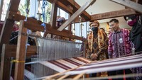 Ketua Dewan Komisioner Otoritas Jasa Keuangan (OJK) Wimboh Santoso didampingi Kepala Otoritas Jasa Keuangan (OJK) Regional VII Sumbagsel Untung Nugroho meninjau pembuatan kain usai meresmikan gedung OJK Kantor Regional VII Sumbagsel di Palembang, Sumatera Selatan, Senin (27/6/2022).