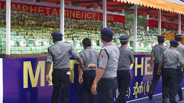 Peringati Hari Narkoba Sedunia, Myanmar Bakar 2 Ton Heroin dan Shabu A police officer and a firefighter walk past burning illegal narcotics during a destruction ceremony on the outskirts of Yangon, Myanmar, Sunday, June 26, 2022. Myanmar authorities burned narcotic drugs worth over $642 million across the country on Sunday, marking the International Day against Drug Abuse and Illicit Trafficking. (AP Photo/Thein Zaw)