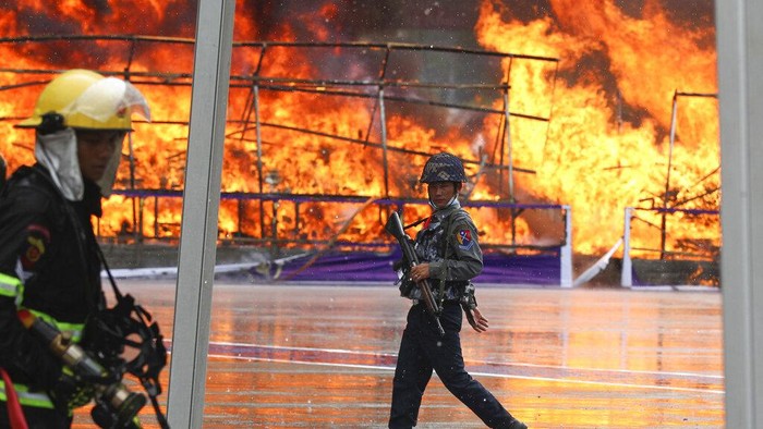 Peringati Hari Narkoba Sedunia, Myanmar Bakar 2 Ton Heroin dan Shabu A police officer and a firefighter walk past burning illegal narcotics during a destruction ceremony on the outskirts of Yangon, Myanmar, Sunday, June 26, 2022. Myanmar authorities burned narcotic drugs worth over $642 million across the country on Sunday, marking the International Day against Drug Abuse and Illicit Trafficking. (AP Photo/Thein Zaw)