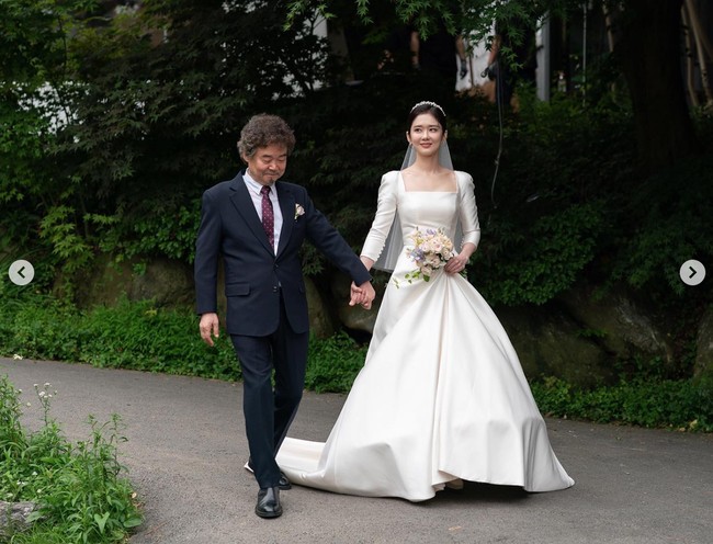 Gaun pengantinnya itu memiliki potongan sederhana namun tetap terkesan anggun dan mewah. Jang Nara memilih gaun putih berbahan satin dengan kerah square neck. Foto: dok. Instagram @goback_jangnara