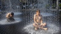 Suhu yang meningkat membuat air mancur publik di kawasan Vilnius ramai didatangi warga, khususnya anak-anak saat akhir pekan. 