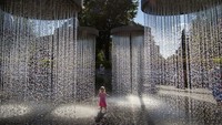 Tampak seorang anak asyik bermain air di pancuran raksasa yang berada di Vilnius, Lithuania, Minggu (26/6/2022) waktu setempat.