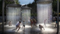 Sejumlah anak asyik bermain air di bawah pancuran raksasa yang berada di kawasan Vilnius, Lithuania, Minggu (26/6/2022) waktu setempat.