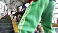 Meski berbahaya, mereka tetap ceria bermain bersama teman sebaya di JPO tersebut.