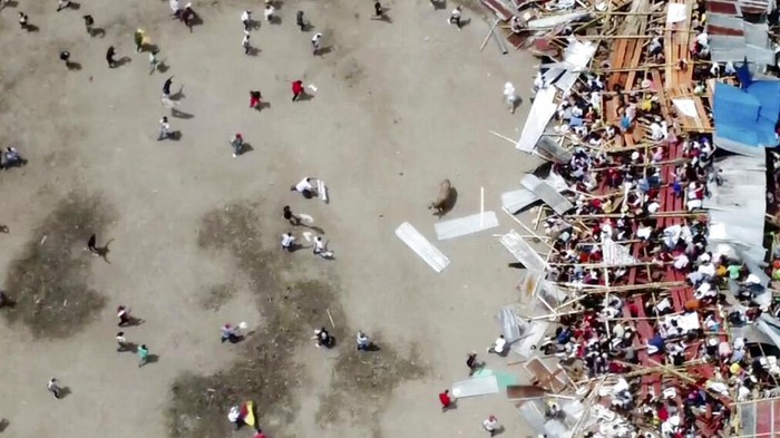In this image taken from video, spectators are sent plunging to the ground as part of a wooden stand collapses during a bullfight, Sunday, June 26, 2022, at a stadium in the city of El Espinal in Tolima state, central Colombia. (AP Video)