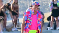 Margot Robbie tampil mengenakan celana ketat berwarna pink dengan pelindung lutut berwarna hijau neon yang mencolok. (Foto: dok. MEGA/GC Images)  