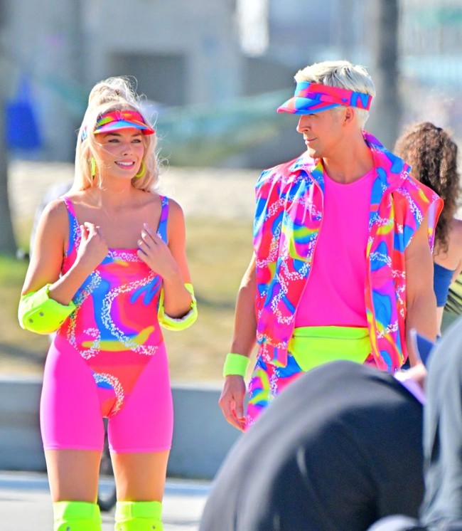 Margot Robbie terlihat memakai visor dengan motif dan warna senada. Ia juga memakai pelindung siku, lutut dan sepatu roda hijau neon. Begitu pula dengan Ryan Gosling. Foto: GC Images/MEGA