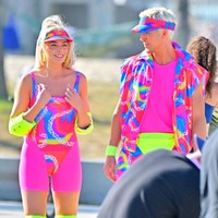 Margot Robbie terlihat memakai visor dengan motif dan warna senada. Ia juga memakai pelindung siku, lutut dan sepatu roda hijau neon. Begitu pula dengan Ryan Gosling. Foto: GC Images/MEGA