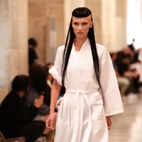 Penampilan Bella Hadid saat sesi latihan. Ia tampak memakai jubah mandi warna putih. Satu lengan digulung, sementara lengan lainnya dibiarkan panjang. (Foto: Getty Images for Marc Jacobs/Dimitrios Kambouris)