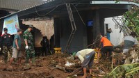 Warga bersama relawan membersihkan material sisa banjir bandang.