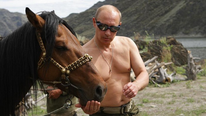 In this photo taken on Monday, Aug. 3, 2009, Russian Prime Minister Vladimir Putin seen feeding a horse  in the mountains of the Siberian Tyva region (also referred to as Tuva),  Russia, during his short vacation. (AP Photo/ RIA Novosti, Alexei Drizhinin, Pool)