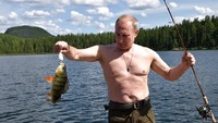 Putin memegang ikan hasil pancingannya saat memancing di wilayah Siberia Tyva. AP/Alexei Nikolsky