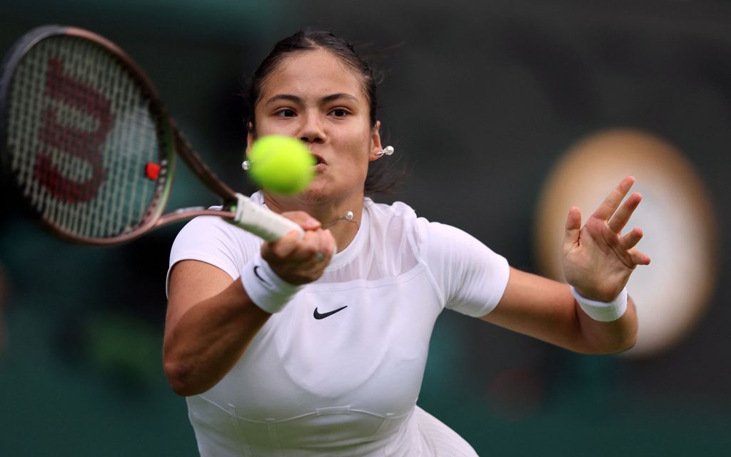 Britain's Emma Raducanu returns the ball to Belgium's Alison van Uytvanck during their women's singles tennis match on the first day of the 2022 Wimbledon Championships at The All England Tennis Club in Wimbledon, southwest London, on June 27, 2022. - RESTRICTED TO EDITORIAL USE (Photo by Adrian DENNIS / AFP) / RESTRICTED TO EDITORIAL USE (Photo by ADRIAN DENNIS/AFP via Getty Images)