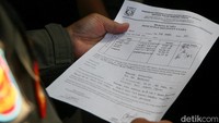 Satpol PP menunjukkan surat tugas untuk penutupan Holywings kepada petugas keamanan bar.